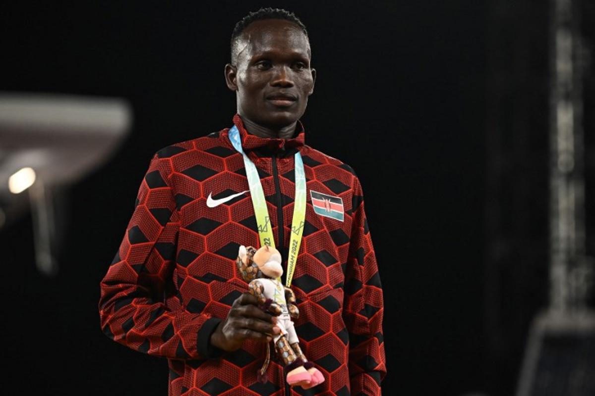 Bronze medallist Kenya's Kibiwott Kandie celebrates on the podium during the medal ceremony for the men's 10,000m athletics event at the Alexander Stadium, in Birmingham on day five of the Commonwealth Games in Birmingham, central England, on August 2, 2022.  Ben Stansall / AFP