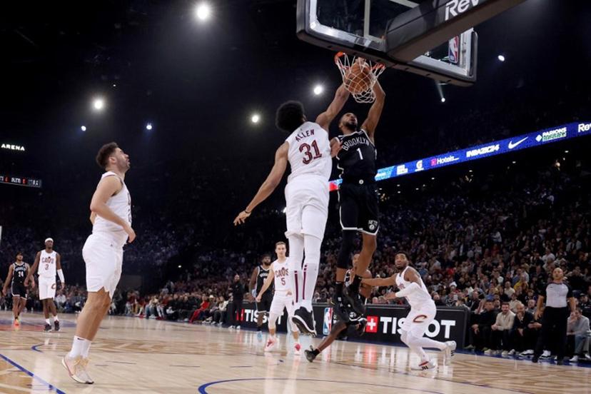 Brooklyn Nets' US Point Guard Mikal Bridges (R) scores in front of Cleveland Cavaliers' US Center Jarrett Allen (L) during the NBA regular season basketball match between the Cleveland Cavaliers and the Brooklyn Nets at the Accor Arena in Paris on January 11, 2024.  EMMANUEL DUNAND / AFP