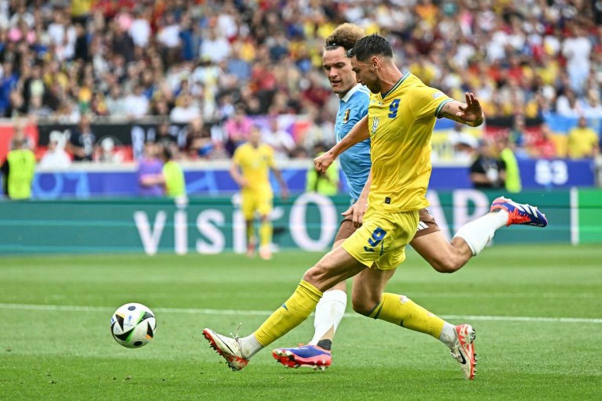 Ukraine's forward #09 Roman Yaremchuk runs with the ball past Belgium's defender #04 Wout Faes during the UEFA Euro 2024 Group E football match between Ukraine and Belgium at the Stuttgart Arena in Stuttgart on June 26, 2024.  Fabrice COFFRINI / AFP