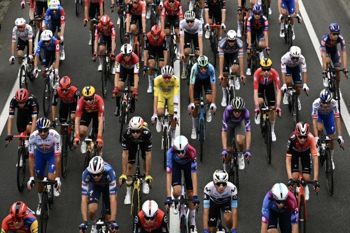 UAE Team Emirates - XRG team's Slovenian rider Tadej Pogacar wearing the overall leader's yellow jersey cycles with the pack of riders (peloton) during the 14th stage of the 112th edition of the Tour de France cycling race, 182.6 km between Pau and Luchon-Superbagneres, in the Pyrenees mountains of southwestern France, on July 19, 2025.  Loic VENANCE / AFP