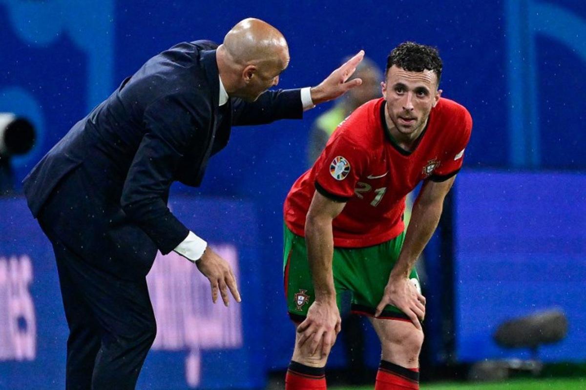 Portugal's head coach Roberto Martinez (L) speaks to Portugal's forward #21 Diogo Jota during the UEFA Euro 2024 Group F football match between Portugal and the Czech Republic at the Leipzig Stadium in Leipzig on June 18, 2024.  JOHN MACDOUGALL / AFP