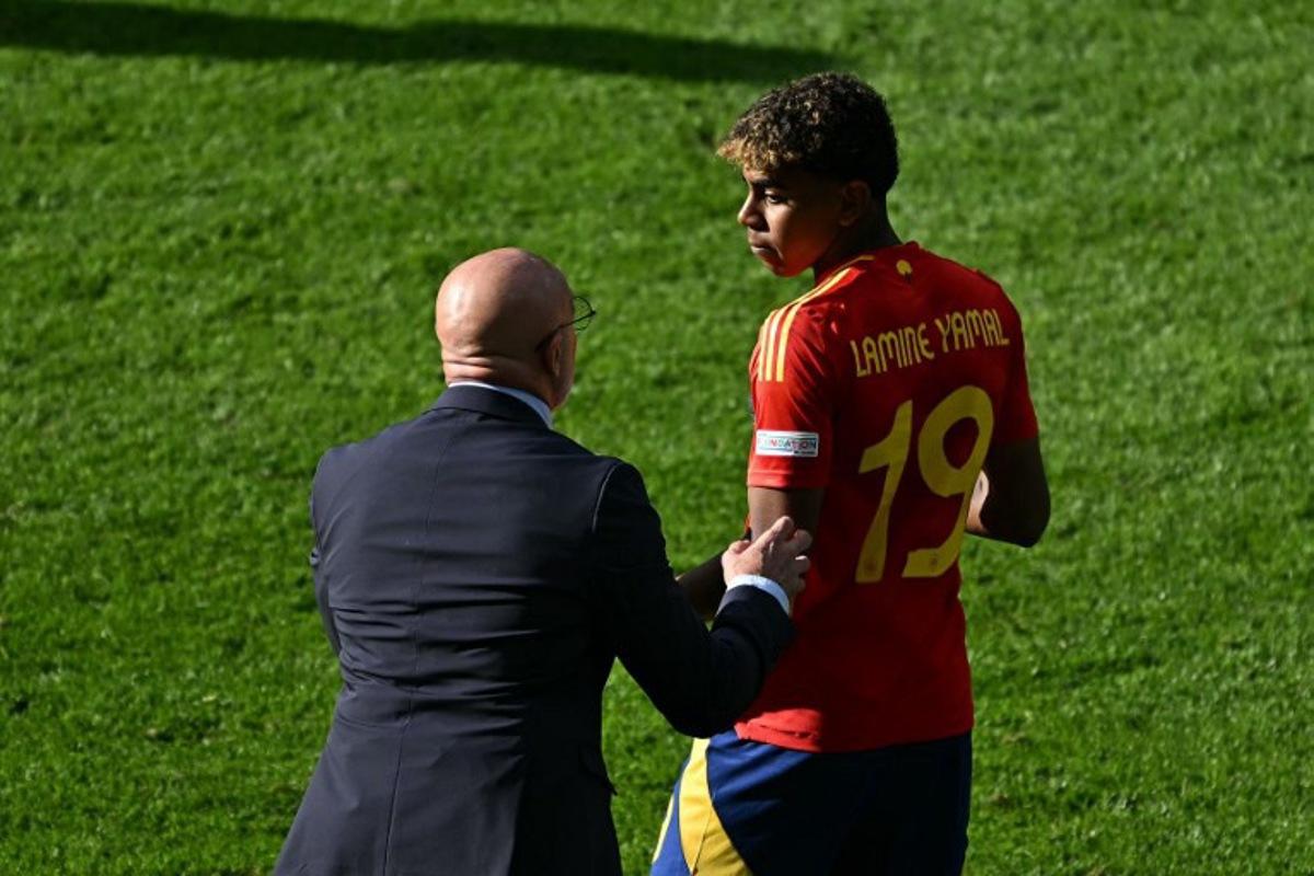 Spain's head coach Luis de la Fuente speaks with Spain's forward #19 Lamine Yamal during the UEFA Euro 2024 Group B football match between Spain and Croatia at the Olympiastadion in Berlin on June 15, 2024.  GABRIEL BOUYS / AFP