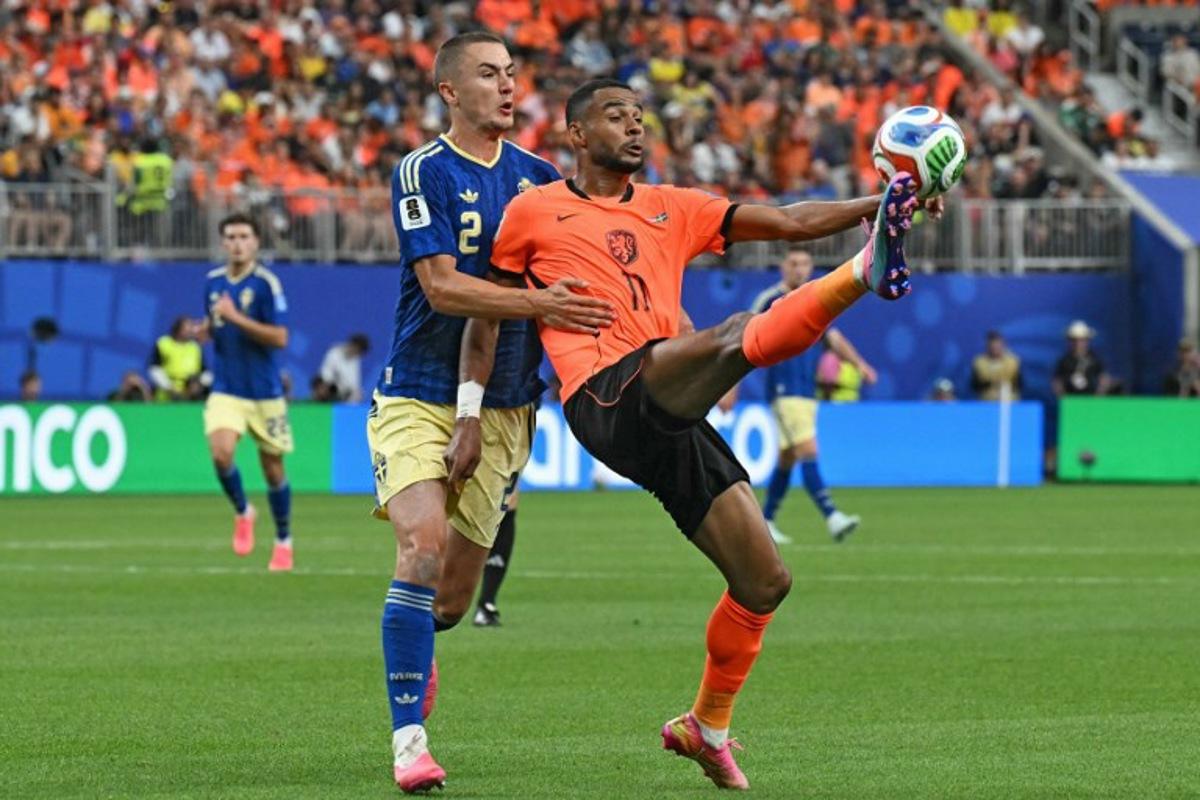 Sweden's defender #02 Gustaf Lagerbielke (L) and Netherlands' forward #11 Cody Gakpo (R) fight for the ball during the 2026 World Cup Group F football match between the Netherlands and Sweden at the Houston Stadium in Houston on June 20, 2026.[cite: 1, 2]   RONALDO SCHEMIDT / AFP