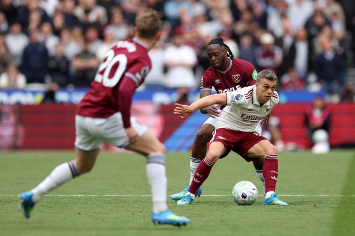 Arsenal's Belgian midfielder #19 Leandro Trossard is put under pressure by West Ham United's English defender #29 Aaron Wan-Bissaka during the English Premier League football match between West Ham United and Arsenal at the London Stadium, in east London on May 10, 2026.  Adrian Dennis / AFP