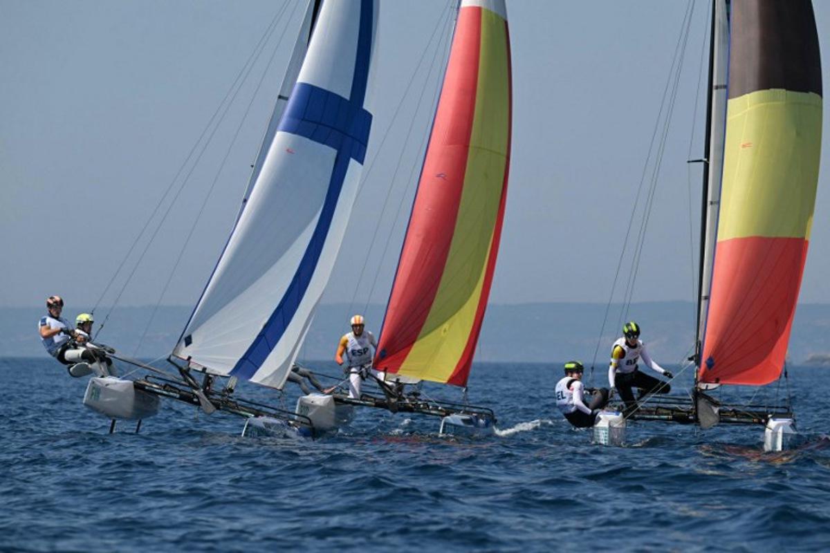 (LtoR) Finland's duo Sinem Kurtbay and Akseli Keskinen, Spain's duo Tara Pacheco van Rijnsoever and Andres Barrio Garcia and Belgium's duo Lucas Claeyssens and Eline Verstraelen compete in race 11 of the mixed Nacra 17 multihull event during the Paris 2024 Olympic Games sailing competition at the Roucas-Blanc Marina in Marseille on August 6, 2024.   NICOLAS TUCAT / AFP
