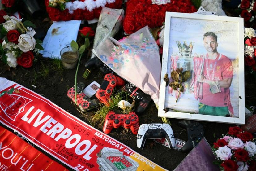 Flowers, games' console controllers and photographs can be seen at a memorial set up close to Anfield football ground for Liverpool's Portuguese forward Diogo Jota ahead of the English Premier League football match between Liverpool and Wolverhampton Wanderers at Anfield in Liverpool, north west England on December 27, 2025. Father of three Jota, who married his long-term partner Rute Cardoso 11 days before the accident, died alongside his brother after a Lamborghini they were travelling in came off the road and burst into flames in northern Spain in July. Oli SCARFF / AFP