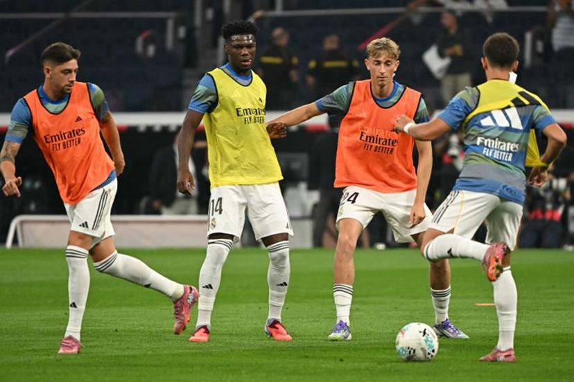 (L to R) Real Madrid's Uruguayan midfielder #08 Federico Valverde, Real Madrid's French midfielder #14 Aurelien Tchouameni and Real Madrid's Spanish defender #24 Dean Huijsen warm up before the Spanish league football match between Real Madrid CF and CA Osasuna at Santiago Bernabeu Stadium in Madrid on August 19, 2025.  JAVIER SORIANO / AFP