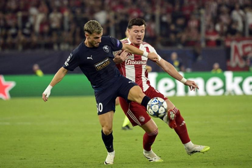 Pafos FC's Romanian midfielder #30 Vlad Dragomir (L) and Olympiakos' French defender #04 Giulian Biancone fight for the ball during the UEFA Champions League football league stage match between Olympiakos and Pafos at the Karaiskakis stadium in Piraeus on September 17, 2025.   Angelos Tzortzinis / AFP