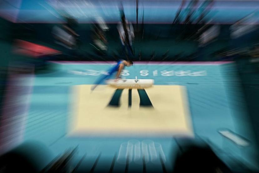 This zooming effet photograph shows an athlete practising in the artistic gymnastics men's pommel horse final during the Paris 2024 Olympic Games at the Bercy Arena in Paris, on August 3, 2024.  Gabriel BOUYS / AFP