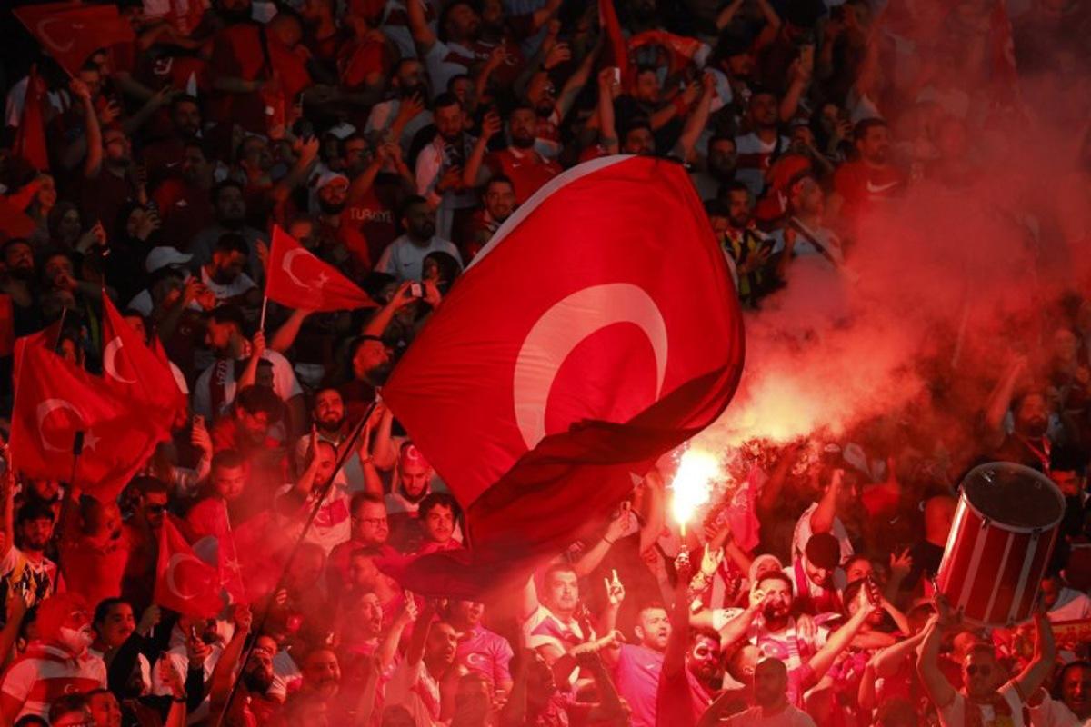 Turkey fans light flares and some make the controversial hand gesture associated with Turkish right-wing extremist group Grey Wolves during the UEFA Euro 2024 quarter-final football match between the Netherlands and Turkey at the Olympiastadion in Berlin on July 6, 2024.  Odd ANDERSEN / AFP
