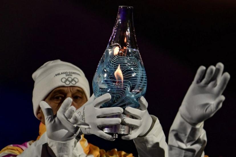 Italy's 1994 Winter Olympics 4×10km cross-country ski relay gold-medal winning team carry the Olympic flame within Murano glass during the closing ceremony of the Milano Cortina 2026 Winter Olympic Games at the Verona Arena in Verona, northern Italy, on February 22, 2026.  Stefano RELLANDINI / AFP