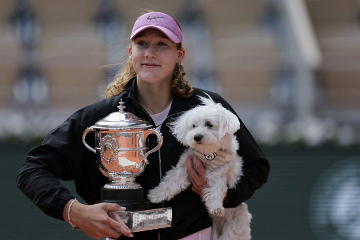 Russia's Mirra Andreeva poses with the Coupe Suzanne Lenglen (Suzanne Lenglen Trophy) and her dog after winning the French Open tennis tournament women's singles final match against Poland's Maja Chwalinska on day 14 of the French Open tennis tournament on Court Philippe-Chatrier at the Roland-Garros Complex in Paris on June 6, 2026.  Thomas SAMSON / AFP