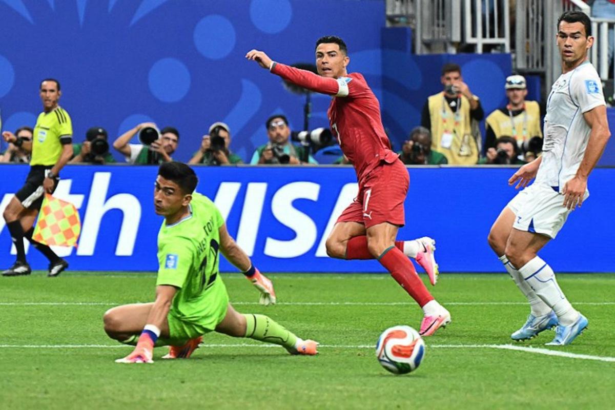 Portugal's forward #07 Cristiano Ronaldo (C) reacts as he scores his team's third goal during the 2026 World Cup Group K football match between Portugal and Uzbekistan at the Houston Stadium in Houston on June 23, 2026.  Scotland and Brazil will meet in a 2026 World Cup Group C football match at the Miami Stadium in Miami Gardens on June 24, 2026. RONALDO SCHEMIDT / AFP