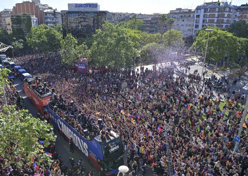 Supporters gather as Barcelona's players celebrate aboard a bus winning their 29th Spanish league title in Barcelona on May 11, 2026. Barcelona secured their 29th Spanish league title after beating Real Madrid 2-0 in the Clasico on May 10, 2026.  MANAURE QUINTERO / AFP