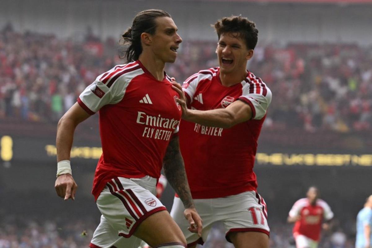 Arsenal's Italian defender #33 Riccardo Calafiori (L) celebrates with Arsenal's Greek striker #17 Christos Tzolis (R) after scoring the opening goal of the English FA Community Shield football match between Arsenal and Manchester City at The Principality Stadium, in Cardiff, south Wales on August 16, 2026.  Glyn KIRK / AFP