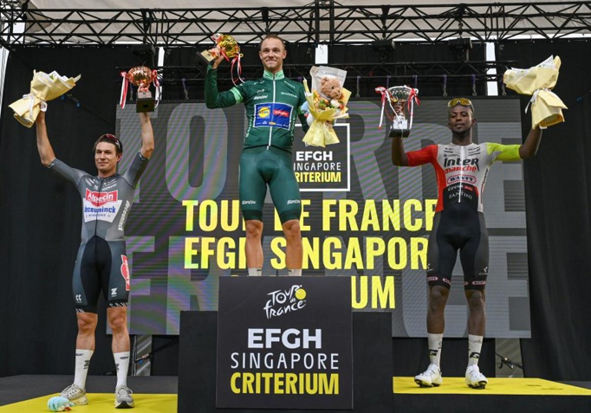 (L-R) Alpecin team's Belgian rider Jasper Philipsen, Lidl - Trek team's Italian rider Jonathan Milan and Intermarche - Wanty team's Eritrean rider Biniam Girmay celebrate on the podium after the 4th Tour de France Singapore Criterium race in Singapore on November 2, 2025. Roslan RAHMAN / AFP