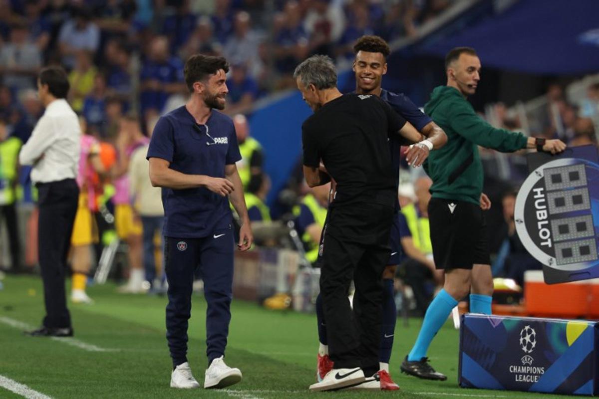 Paris Saint-Germain's French midfielder #14 Desire Doue (2R) is embraced by Paris Saint-Germain's Spanish headcoach Luis Enrique (C) as he is substituted during the UEFA Champions League final football match between Paris Saint-Germain (PSG) and Inter Milan in Munich, southern Germany, on May 31, 2025. FRANCK FIFE / AFP