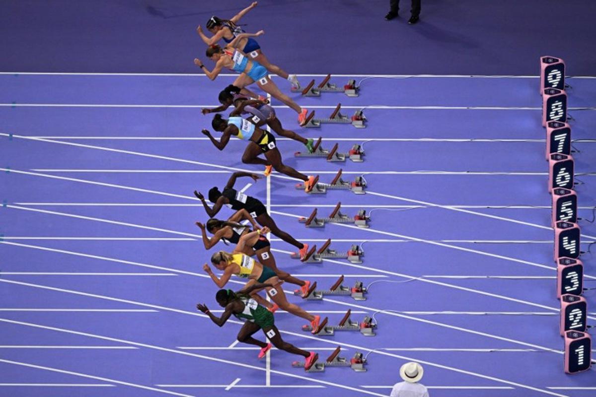 An overview shows Puerto Rico's Gladymar Torres, Luxembourg's Patrizia Van Der Weken, US' Sha'Carri Richardson, St Lucia's Julien Alfred, Gambia's Gina Mariam Bass Bittaye, Britain's Imani Lansiquot, Australia's Bree Masters taking the start and the empty line of Jamaica's Shelly-Ann Fraser-Pryce (C) in the women's 100m semi-final of the athletics event at the Paris 2024 Olympic Games at Stade de France in Saint-Denis, north of Paris, on August 3, 2024. Antonin THUILLIER / AFP