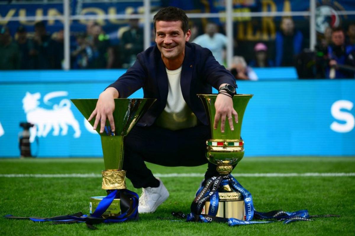 Inter Milan's Romanian head coach Cristian Chivu poses with the trophies for the Italian Cup and the 21st scudetto (Italian Championship victory) at San Siro stadium after the Italian Serie A football match between Inter Milan and Hellas Verona in Milan, on May 17, 2026. Marco BERTORELLO / AFP