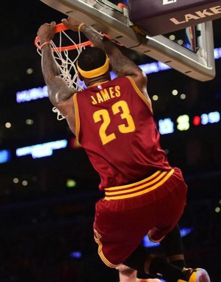 LeBron James of the Cleveland Cavaliers hangs onto the rim after failing to score off a slam dunk as the ball bounced off the rim against the Los Angeles Lakers during their NBA game at Staples Center in Los Angeles, California on January 15, 2014. AFP PHOTO/Frederic J. BROWN