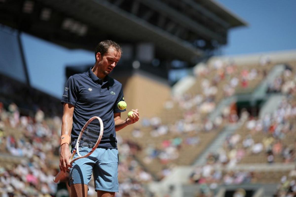 Daniil Medvedev selects a ball as he prepares to serve to Australia's Adam Walton during their men's singles match on day 3 of the French Open tennis tournament on Court Suzanne-Lenglen at the Roland-Garros Complex in Paris on May 26, 2026. Thomas SAMSON / AFP