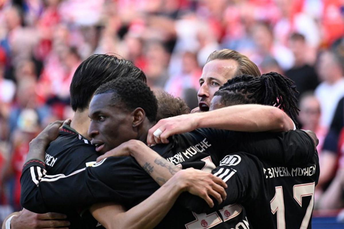 Bayern Munich's English forward #09 Harry Kane celebrates with team mates after scoring his team's fourth goal 3:4 during the German first division Bundesliga football match between 1 FSV Mainz 05 and FC Bayern Munich in Mainz, western Germany on April 25, 2026. Kirill KUDRYAVTSEV / AFP