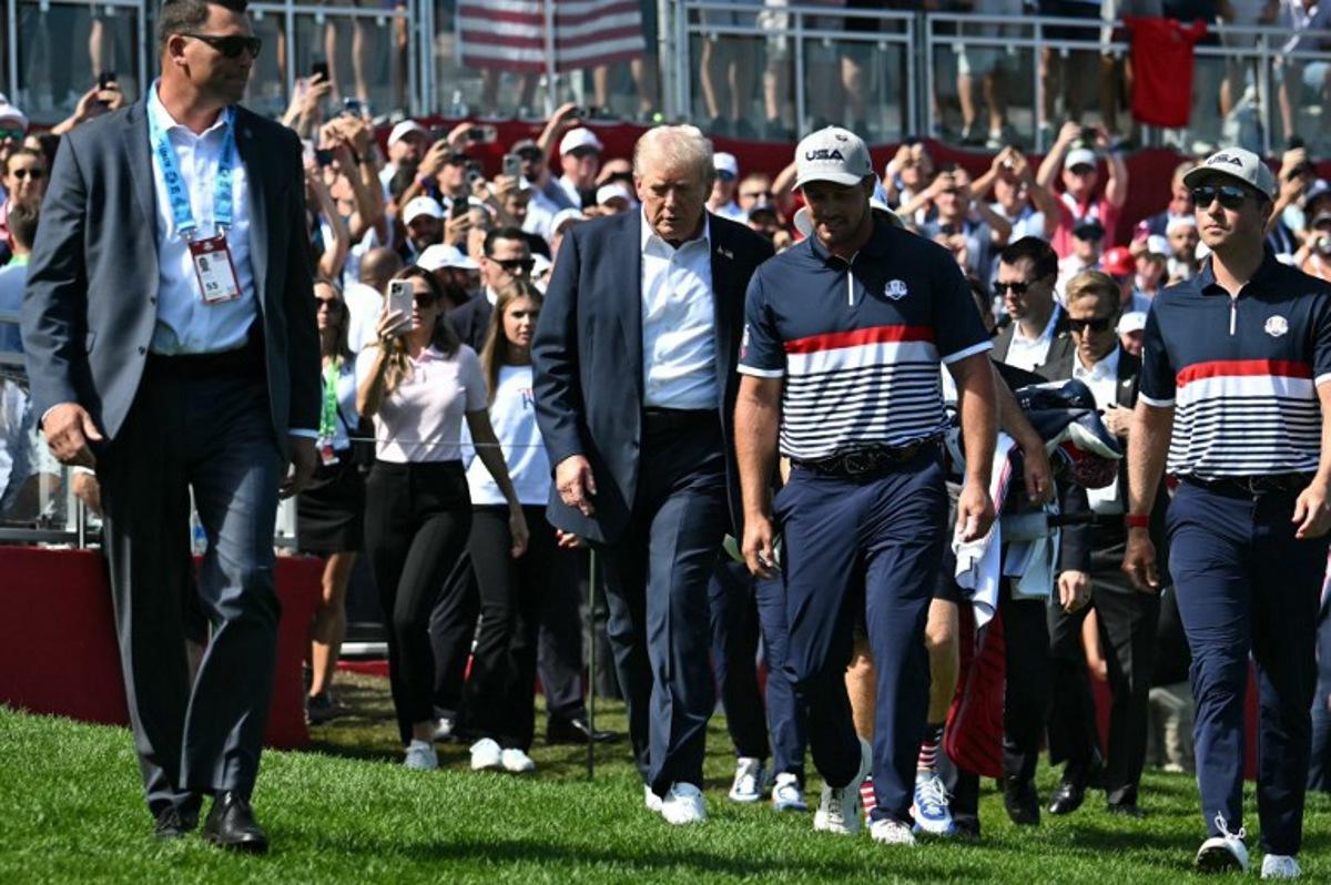 US President Donald Trump walks with pro-golfer Bryson DeChambeau (2R) as he attends the 45th Ryder Cup golf competition at Bethpage Black Course in Farmingdale, New York, on September 26, 2025. Mandel NGAN / POOL / AFP