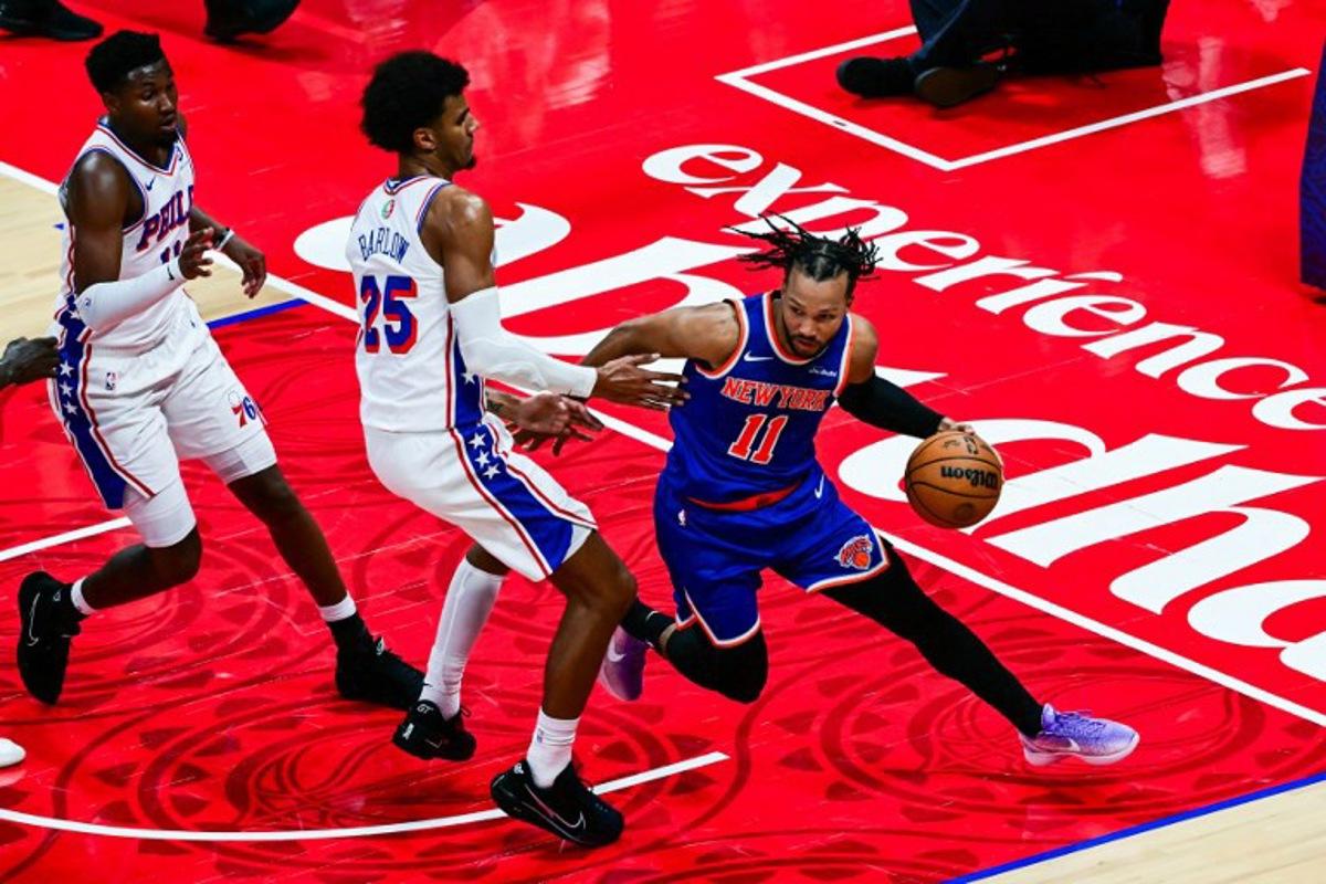 New York Knicks' #11 Jalen Brunson dribbles against Philadelphia 76ers' #25 Dominick Barlow during the NBA basketball game between the New York Knicks and the Philadelphia 76ers at the Etihad Arena in Abu Dhabi on October 4, 2025. Giuseppe CACACE / AFP