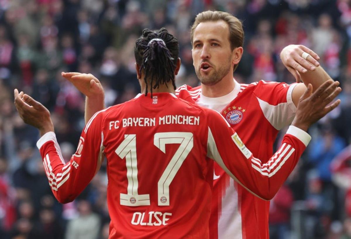 Bayern Munich's French midfielder #17 Michael Olise celebrates his 1-0 with Bayern Munich's English forward #09 Harry Kane during the German first division Bundesliga football match between FC Bayern Munich and Union Berlin in Munich, southern Germany, on March 21, 2026. Karl-Josef HILDENBRAND / AFP