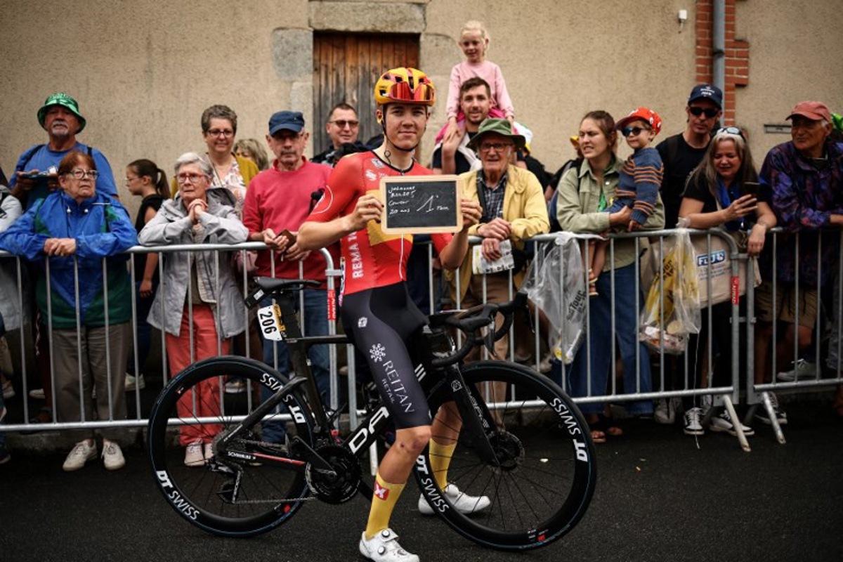 This photograph taken on July 10, 2024, shows Uno-X Mobility team's Norwegian rider Johannes Kulset posing with the chalkboad indicating his first Tour de France attendance at the start of the 11th stage of the 111th edition of the Tour de France cycling race, 211 km between Évaux-les-Bains and Le Lioran. Anne-Christine POUJOULAT / AFP