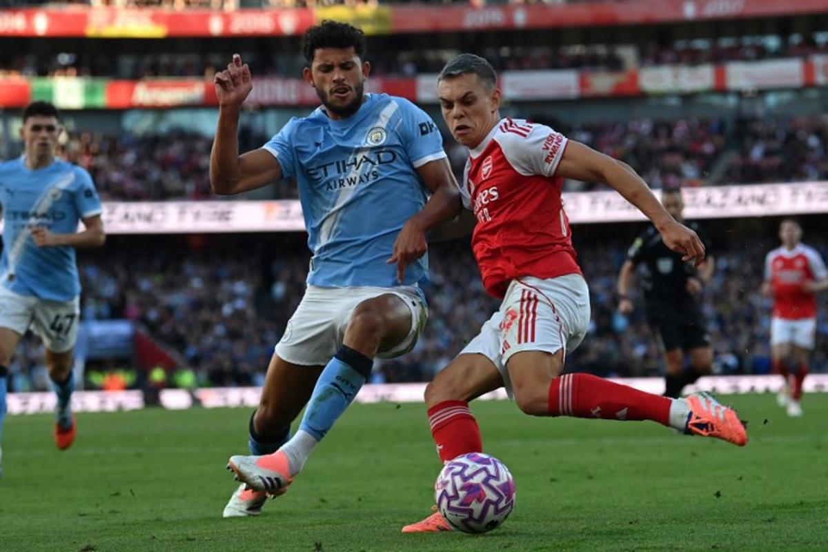 Manchester City's Portuguese midfielder #27 Matheus Nunes (L) vies with Arsenal's Belgian midfielder #19 Leandro Trossard (R) during the English Premier League football match between Arsenal and Manchester City at the Emirates Stadium in London on September 21, 2025. Glyn KIRK / AFP