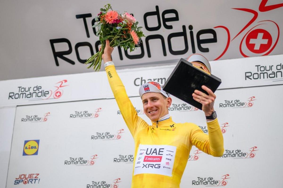 UAE Team Emirates-XRG's Slovenian rider Tadej Pogacar wearing the overall leader's yellow jersey celebrates during the podium ceremony after winning the fourth stage of the Tour of Romandie UCI cycling World tour, 149.6 km from Broc and to Charmey, in Charmey, Switzerland, on May, 2, 2026. Fabrice COFFRINI / AFP