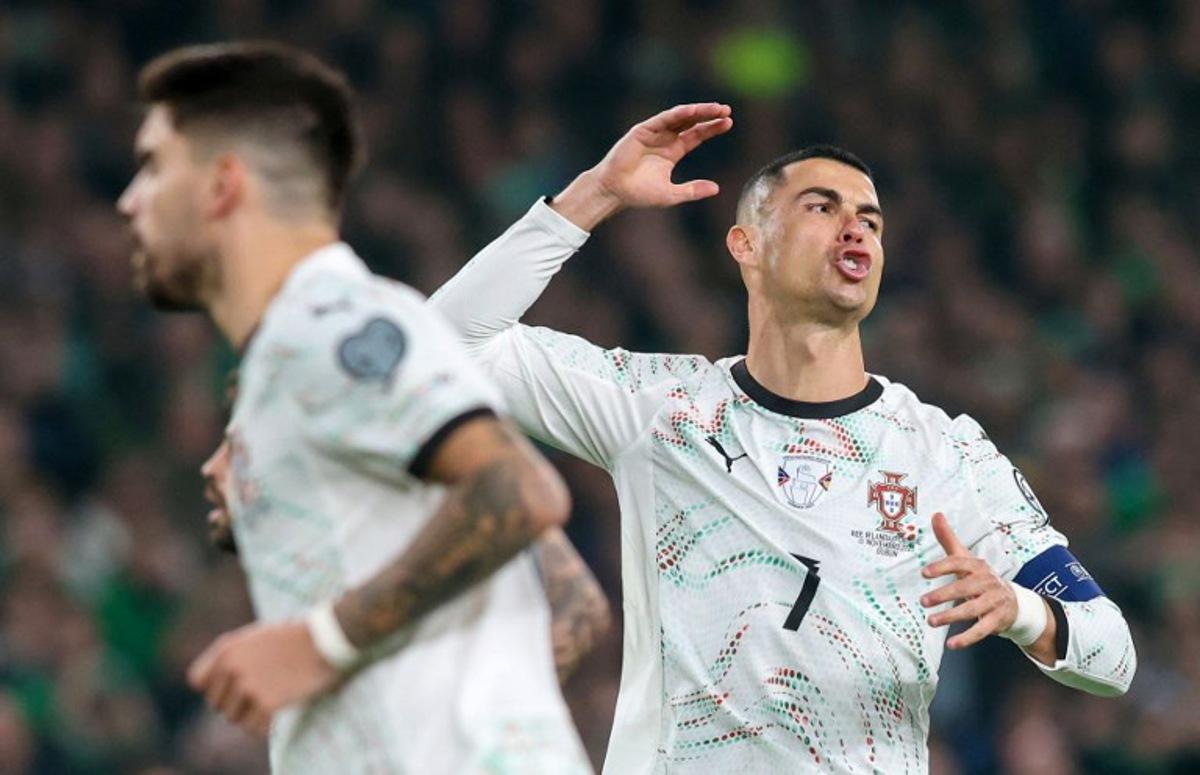 Portugal's forward Cristiano Ronaldo (R) reacts after missing a free kick during the men's football 2026 World Cup Group F qualifier between Ireland and Portugal at Aviva Stadium in Dublin on November 13, 2025. Paul Faith / AFP