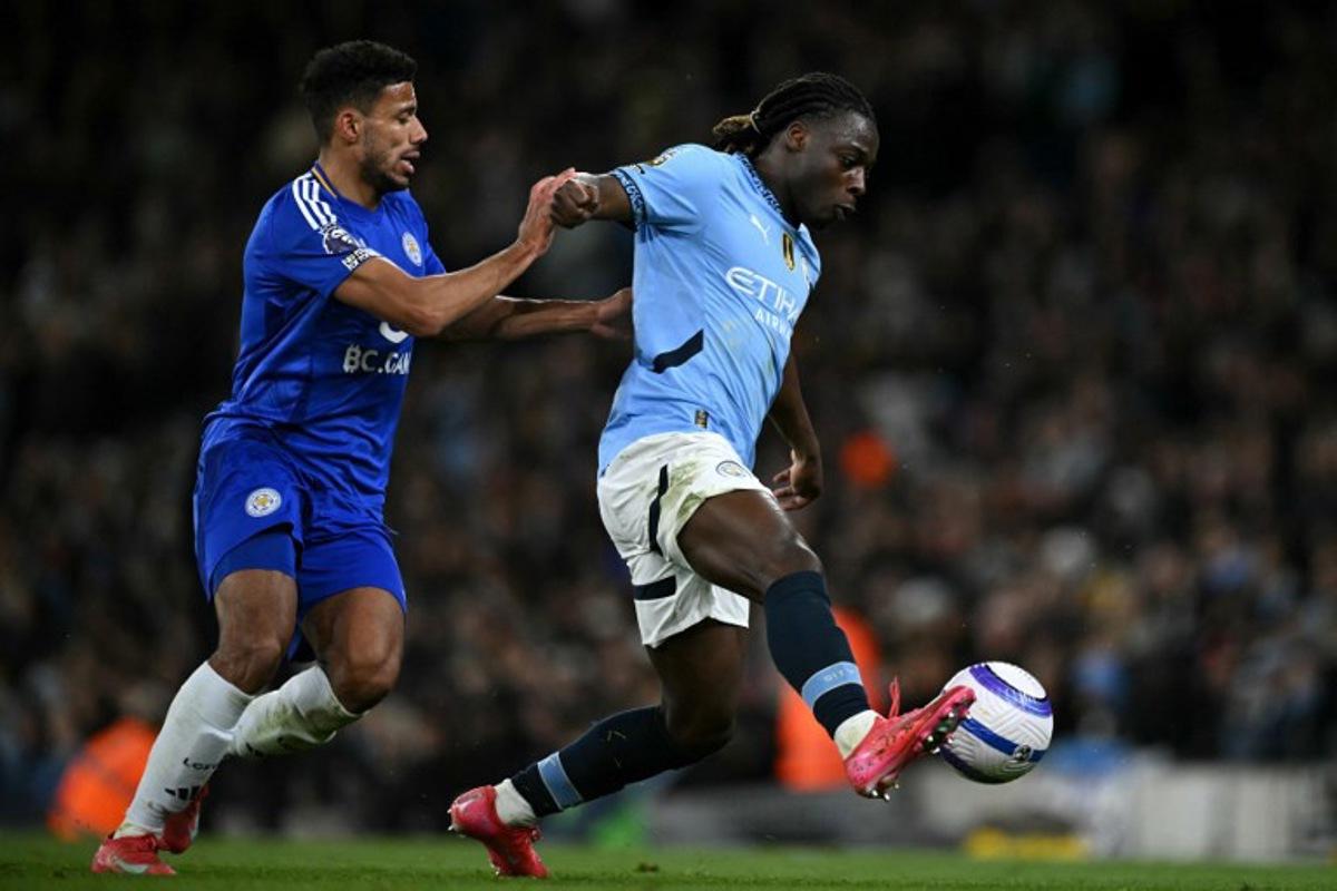 Leicester City's English defender #02 James Justin battles for the ball with Manchester City's Belgian midfielder #11 Jeremy Doku during the English Premier League football match between Manchester City and Leicester City at the Etihad Stadium in Manchester, north west England, on April 2, 2025. Oli SCARFF / AFP