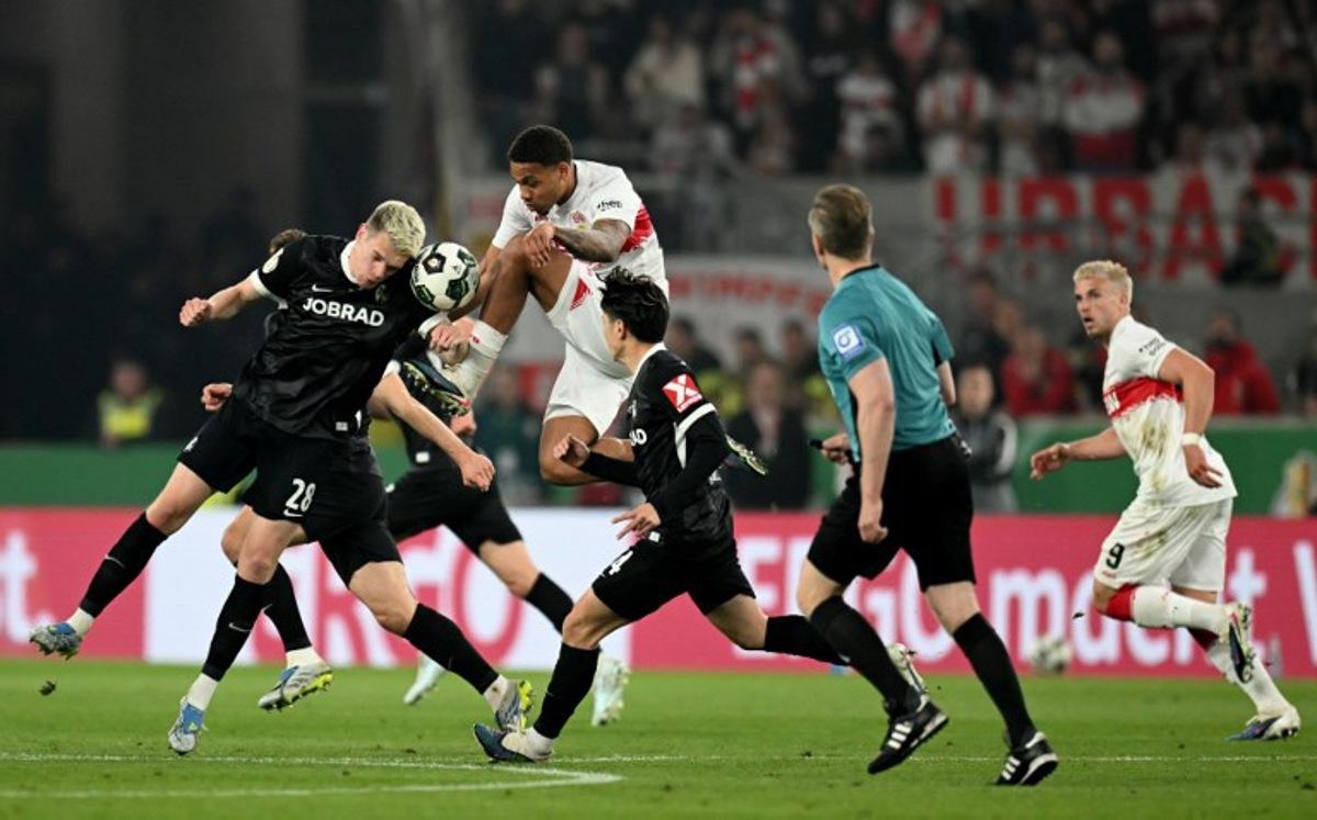 Stuttgart's Danish midfielder #28 Nikolas Nartey (top) and Freiburg's German defender #28 Matthias Ginter (L) vie for the ball during the German Cup (DFB-Pokal) semi-final football match between VfB Stuttgart and FC Freiburg in Stuttgart, southwestern Germany, on April 23, 2026. THOMAS KIENZLE / AFP