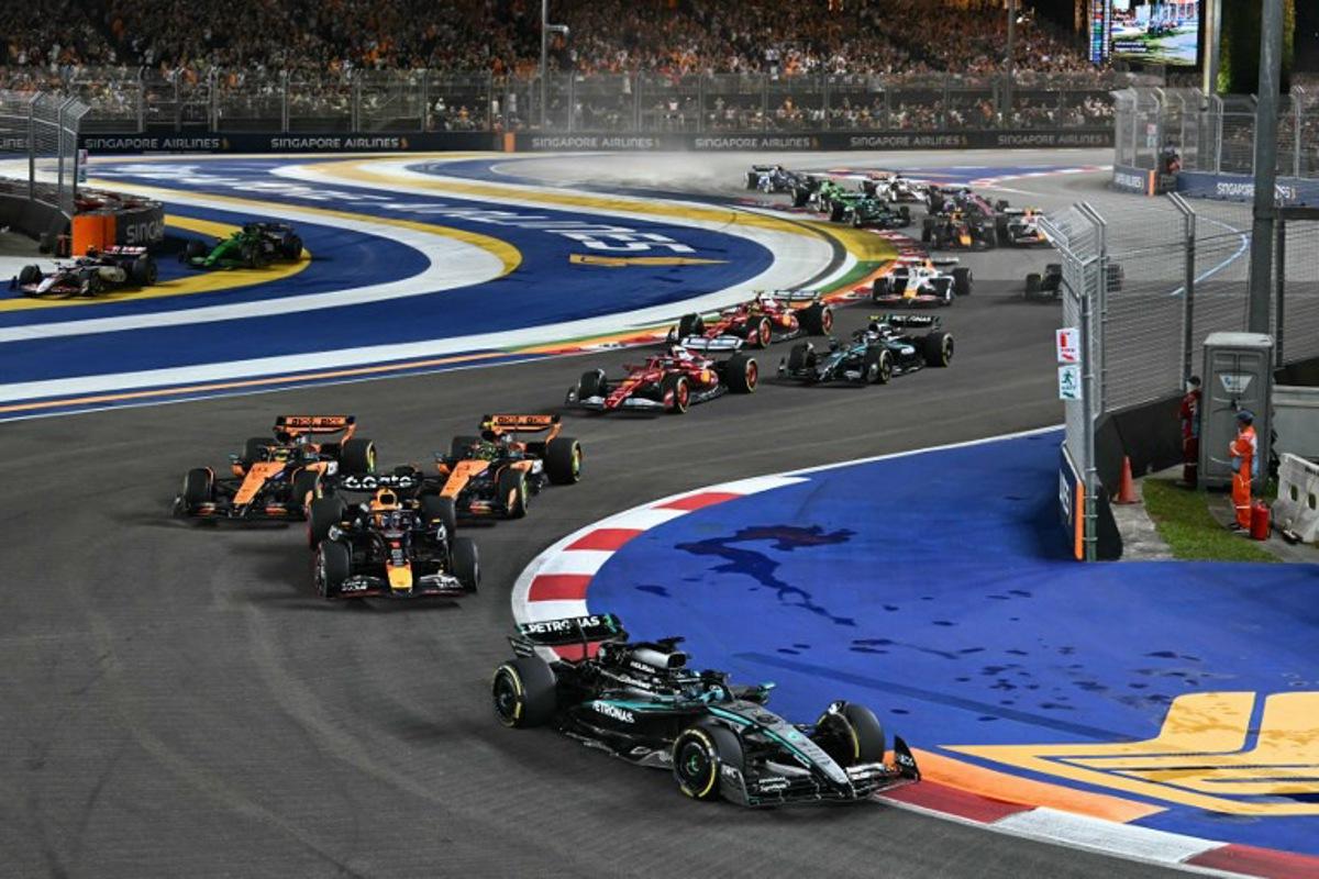 Mercedes' British driver George Russell leads ahead of Red Bull Racing's Dutch driver Max Verstappen at the start of the Formula One Singapore Grand Prix night race at the Marina Bay Street Circuit in Singapore on October 5, 2025. MOHD RASFAN / AFP
