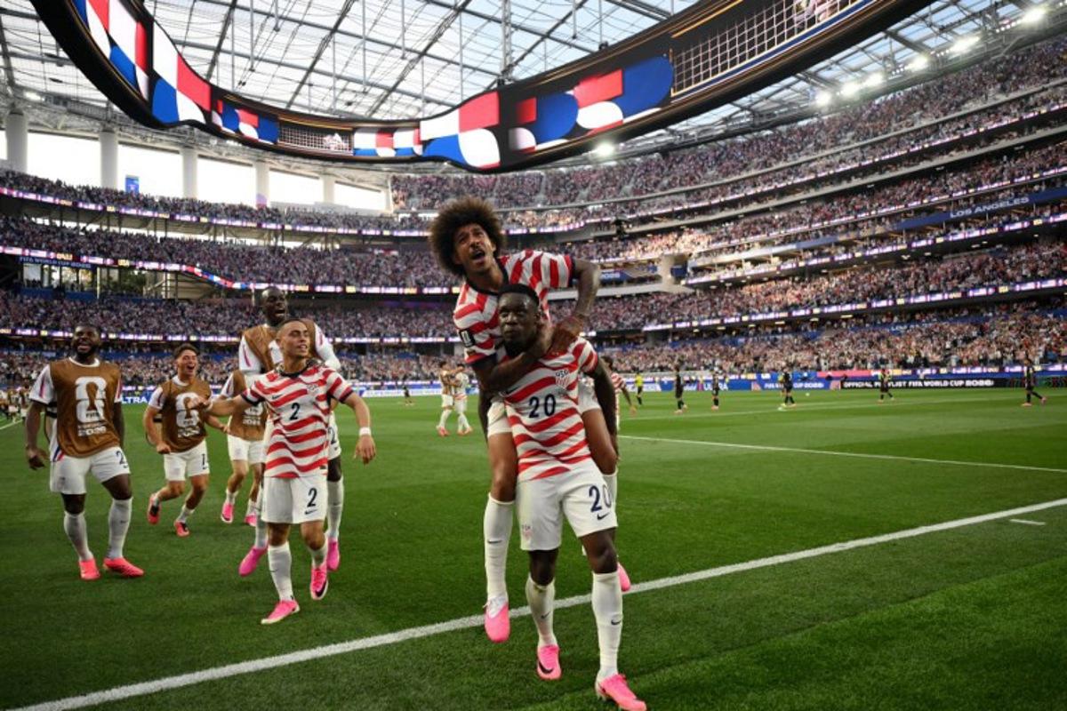 US forward #20 Folarin Balogun celebrates with teammates after scoring his team's third goal during the 2026 World Cup Group D football match between USA and Paraguay at the Los Angeles Stadium in Inglewood on June 12, 2026. Patrick T. Fallon / AFP