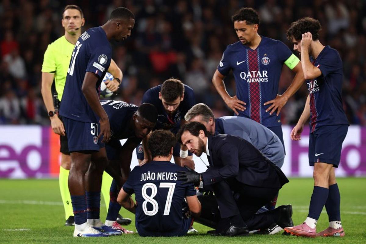 Paris Saint-Germain's Portuguese midfielder #87 Joao Neves (C) sits on the pitch as he receives medical attention during the UEFA Champions League first round day 1 football match between Paris Saint-Germain (FRA) and Atalanta (ITA) at the Parc des Princes stadium in Paris on September 17, 2025. FRANCK FIFE / AFP