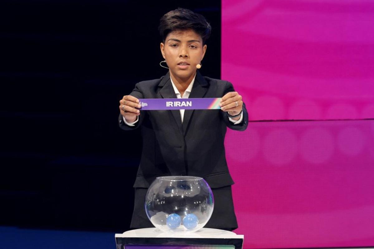 Indian footballer Sangita Basfore holds up Iran during the 2026 AFC Women's Asian Cup football draw in Sydney on July 29, 2025. The 2026 AFC Women's Asian Cup will be hosted by Australia, and will run from March 1-21, 2026. DAVID GRAY / AFP