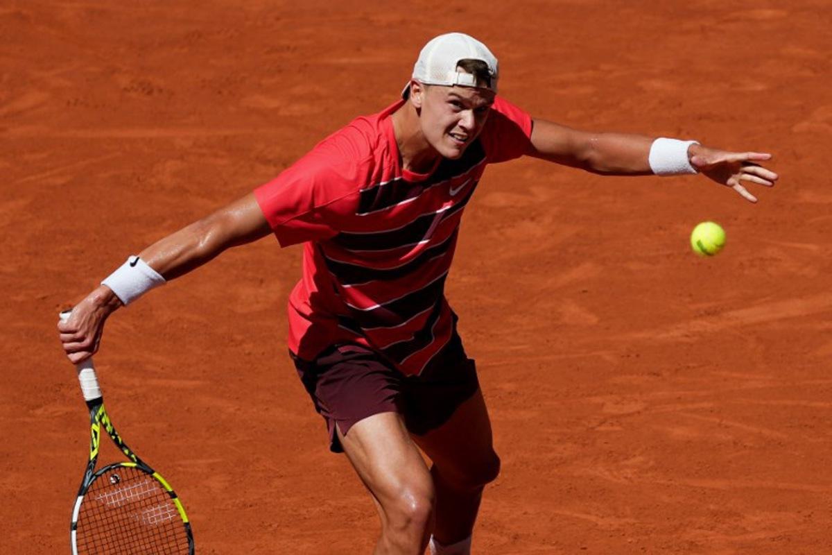 Denmark's Holger Rune plays a backhand return to France's Quentin Halys during their men's singles match on day 6 of the French Open tennis tournament on Court Philippe-Chatrier at the Roland-Garros Complex in Paris on May 30, 2025. Dimitar DILKOFF / AFP