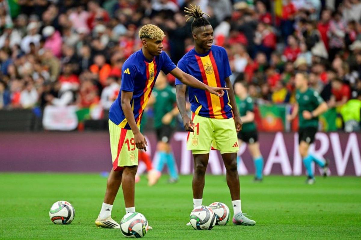 Spain's forward #19 Lamine Yamal (L) and Spain's forward #11 Nico Williams practice shooting during the warm up prior to the UEFA Nations League final football match between Portugal and Spain in Munich, southern Germany on June 8, 2025. John MACDOUGALL / AFP