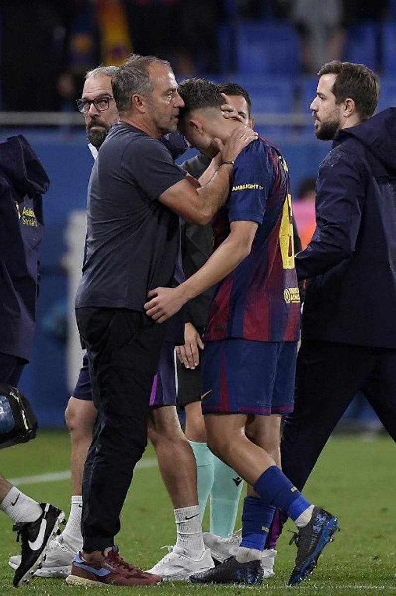Barcelona's German coach Hans-Dieter Flick comforts Barcelona's Spanish midfielder #16 Fermin Lopez injured during the Spanish league football match between FC Barcelona and Getafe CF at Johan Cruyff Stadium in Barcelona on September 21, 2025. Josep LAGO / AFP