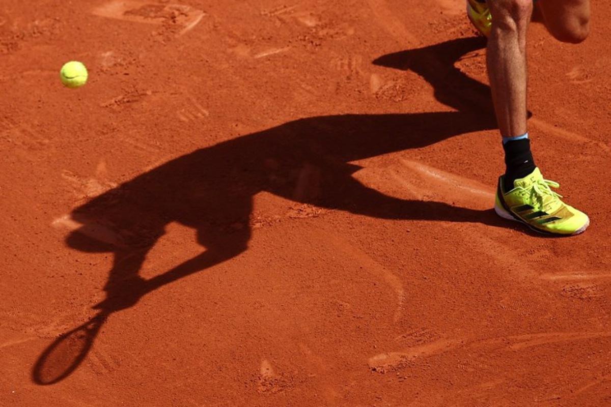 The shadow of Germany's Alexander Zverev playing a backhand to Italy's Flavio Cobolli is casted on the clay during their men's singles match on day 7 of the French Open tennis tournament on Court Philippe-Chatrier at the Roland-Garros Complex in Paris on May 31, 2025. Anne-Christine POUJOULAT / AFP