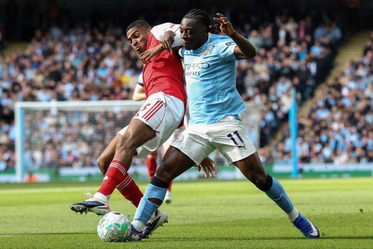 Arsenal's Spanish defender #03 Christhian Mosquera (L) is challenged by Manchester City's Belgian midfielder #11 Jeremy Doku (R) during the English Premier League football match between Manchester City and Arsenal at the Etihad Stadium in Manchester, north west England, on April 19, 2026. Darren Staples / AFP