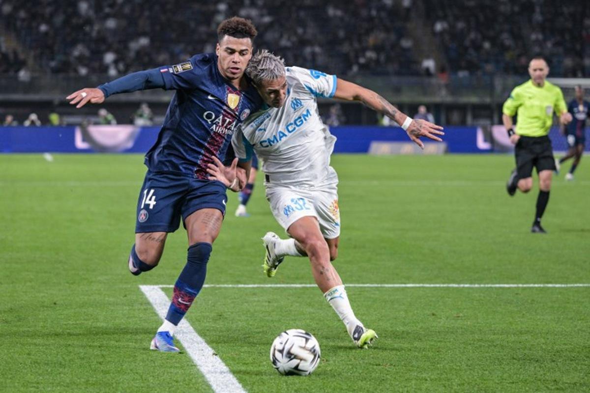 Paris Saint-Germain's French midfielder #14 Desire Doue (L) fights for the ball with Marseille's Argentinian defender #32 Facundo Medina during the French Champions' Trophy (Trophee des Champions) football match between Paris Saint-Germain (PSG) and Olympique de Marseille (OM) at the Jaber Al-Ahmad International Stadium in Kuwait City on January 8, 2026. Yasser AL ZAYYAT / AFP