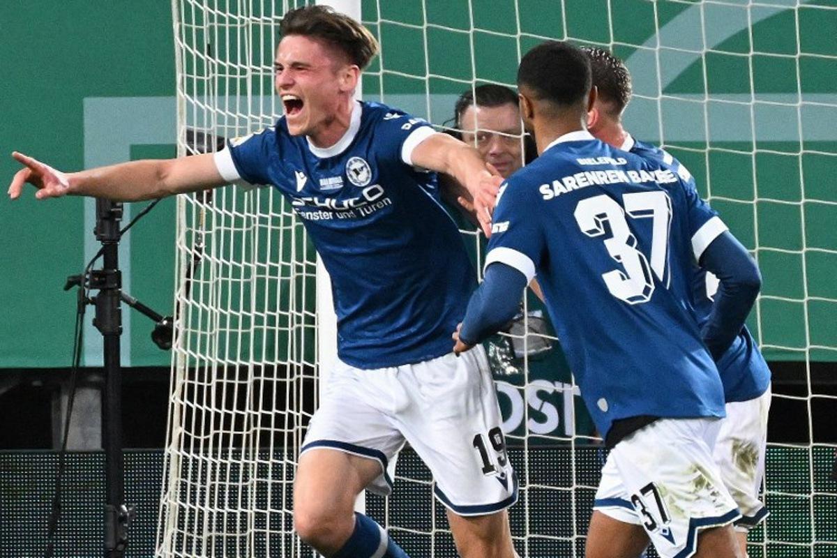 Arminia Bielefeld's German defender #19 Maximilian Grosser (L) celebrates scoring the 2-1 goal with his teammates during the German Cup (DFB Pokal) semi-final football match between Arminia Bielefeld and Bayer 04 Leverkusen in Bielefeld, western Germany on April 1, 2025. UWE KRAFT / AFP