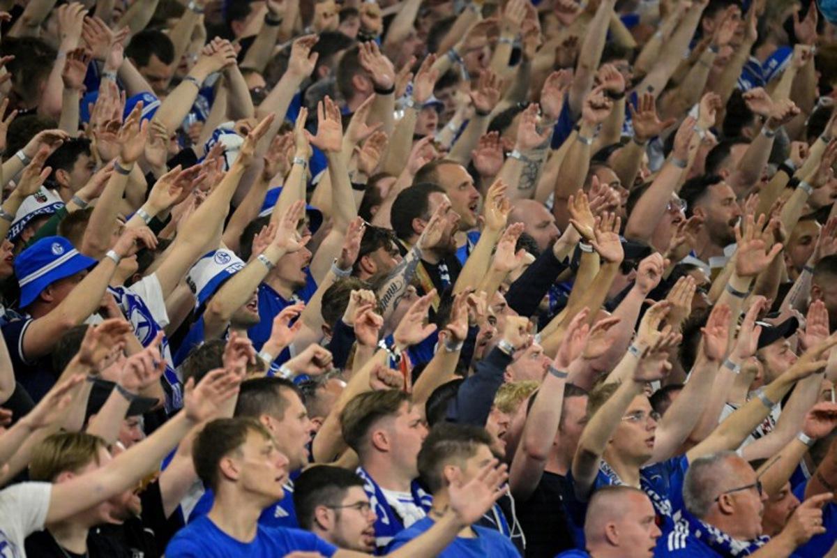 Schalke fans cheer during the German second division Bundesliga football match between FC Schalke 04 and Fortuna Duesseldorf at the Veltins Arena in Gelsenkirchen, western Germany on May 2, 2026. Schalke are pushing to return to the first division next season with a win against Fortuna Duesseldorf on May 2, 2026. INA FASSBENDER / AFP