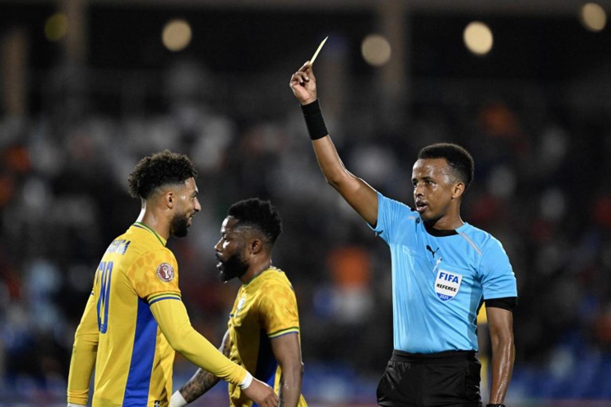 (FILES) Gabon's forward #20 Denis Bouanga is shown the yellow card by Somali referee Omar Abdulkadir Artan during the Africa Cup of Nations (CAN) Group F football match between Gabon and Ivory Coast at the Grand Stadium in Marrakech on December 31, 2025. Award-winning Somali referee Omar Artan, set to be the first from his country to officiate at the World Cup, was denied entry to the United States, a sports ministry official told AFP on June 8, 2026. "Denying him entry to the United States and preventing him from officiating scheduled matches harms not only him personally but also undermines football's commitment to fairness, merit, and the spirit of fair play," Ciise Aden Abshir, a senior advisor to Somalia's Ministry of Youth and Sports and a former national team captain, told AFP. Khaled DESOUKI / AFP