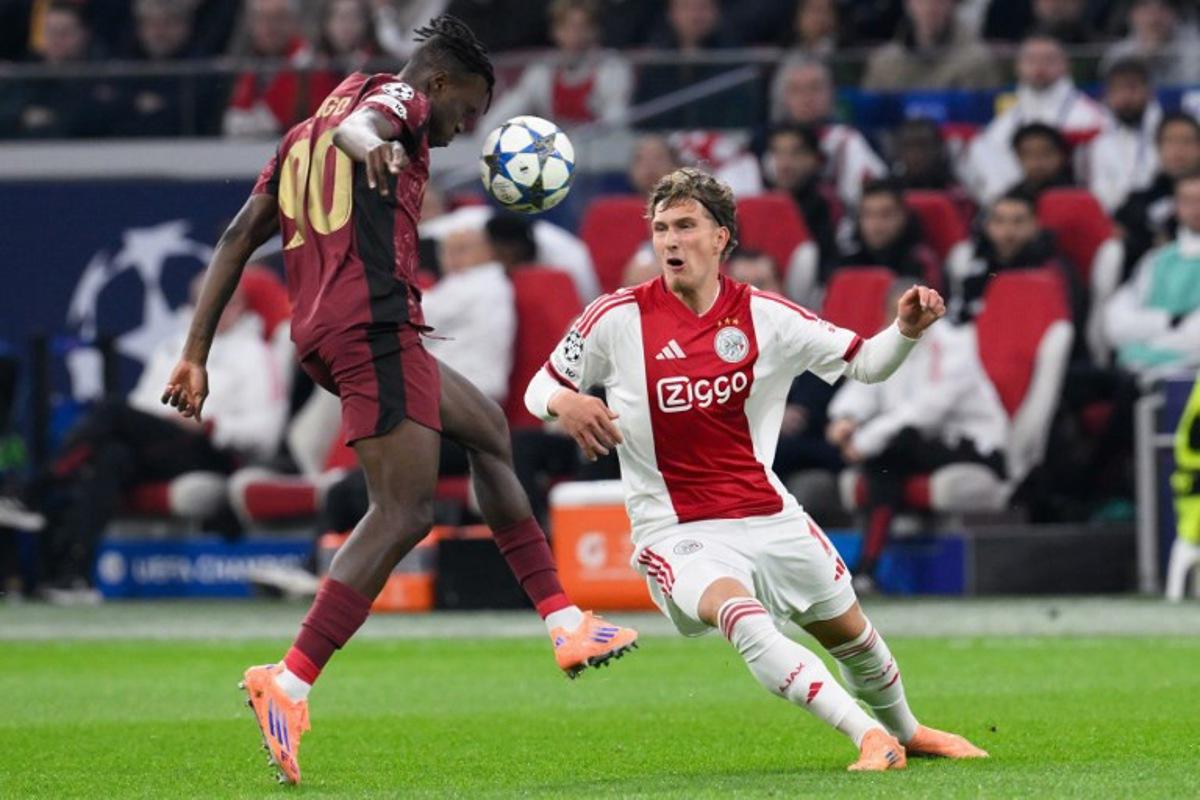 Galatasaray's Ivorian defender #90 Wilfried Singo (L) fights for the ball with Ajax's Belgian forward #11 Mika Godts (R) during the UEFA Champions League, league phase day 4, football match between Ajax and Galatasaray at the Johan Cruijff ArenA in Amsterdam on November 5, 2025. JOHN THYS / AFP