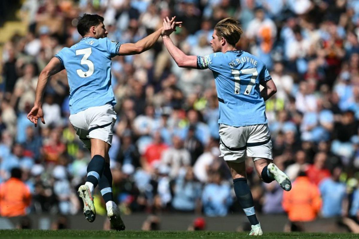 Manchester City's Belgian midfielder #17 Kevin De Bruyne (R) celebrates with Manchester City's Portuguese defender #03 Ruben Dias (L) after scoring their first goal during the English Premier League football match between Manchester City and Crystal Palace at the Etihad Stadium in Manchester, north west England, on April 12, 2025. Paul ELLIS / AFP